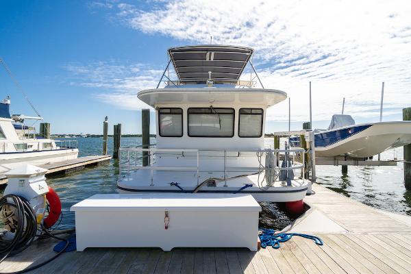 Slide: The Image of 2003 Gibson 47 Classic houseboat docked at marina under clear sky. - 2