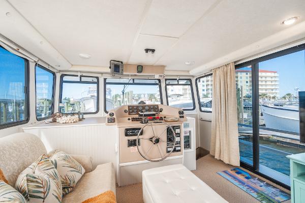 Slide: The Image of Interior of 2003 Gibson 47 Classic boat with helm, seating, and marina view. - 24