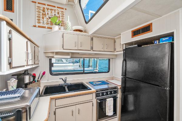 Slide: The Image of Compact kitchen in a 2003 Gibson 47 Classic boat with modern appliances and waterfront view. - 26