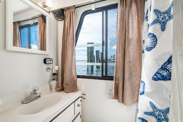 Slide: The Image of Bathroom with ocean view, featuring seashell shower curtain and modern sink in 2003 Gibson 47 Classic. - 27