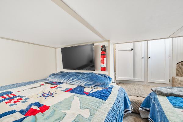 Slide: The Image of Cozy bedroom with nautical-themed bedding, TV, and fire extinguisher on a 2003 Gibson 47 Classic. - 36