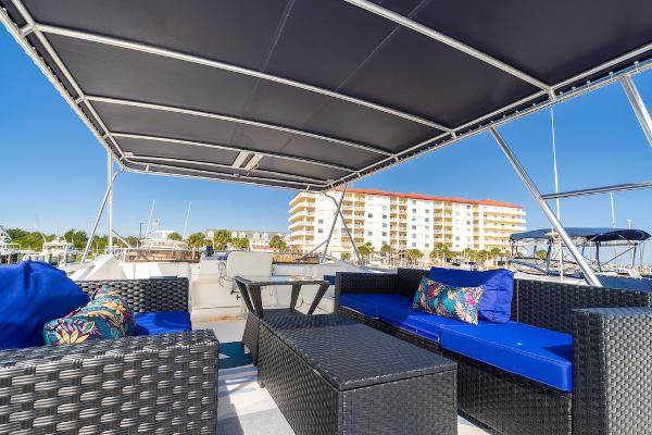 Slide: The Image of Gibson 47 Classic 2003 boat with outdoor seating, blue cushions, and marina view. - 4