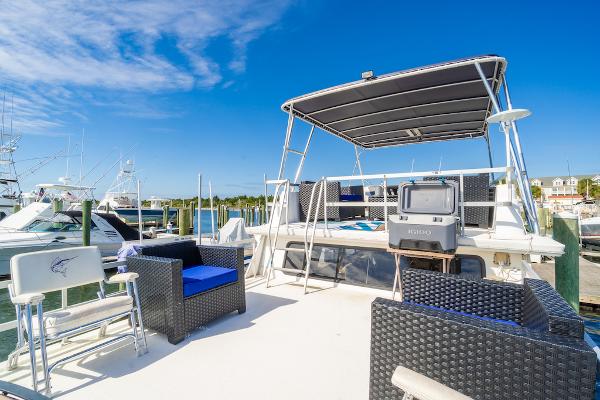 Slide: The Image of 2003 Gibson 47 Classic yacht deck with seating and TV under a clear blue sky. - 8