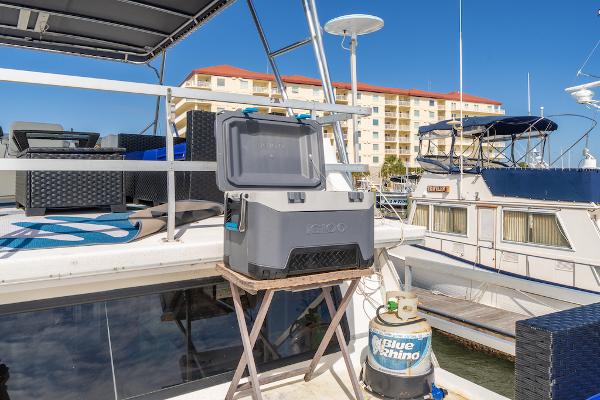 Slide: The Image of Gibson 47 Classic yacht with cooler and propane tank on deck, docked near waterfront buildings. - 9