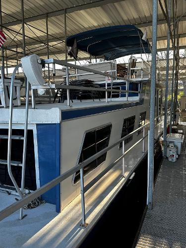 Slide: The Image of 1987 Gibson 50 Classic houseboat docked in a covered marina. - 11