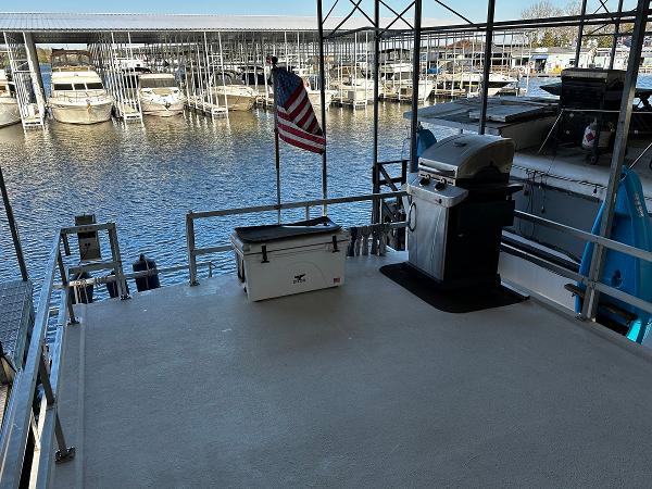 Slide: The Image of Upper deck of 1987 Gibson 50 Classic houseboat with grill and cooler, docked at marina. - 14