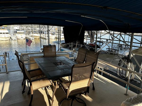 Slide: The Image of Covered deck of a 1987 Gibson 50 Classic houseboat with outdoor dining set. - 16