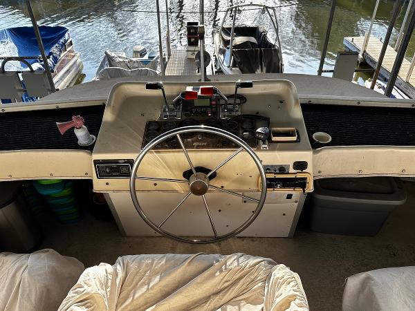 Slide: The Image of Control console of a 1987 Gibson 50 Classic boat docked at a marina. - 17