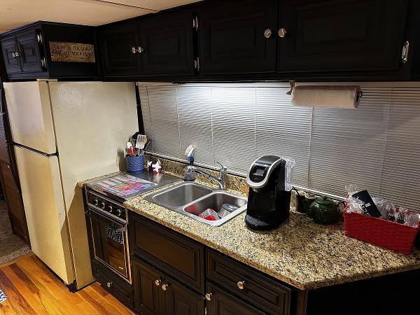 Slide: The Image of 1987 Gibson 50 Classic kitchen with granite countertops, black cabinets, and stainless steel sink. - 19