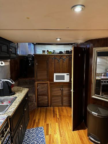 Slide: The Image of 1987 Gibson 50 Classic boat interior with wooden cabinets, microwave, and modern kitchen amenities. - 22