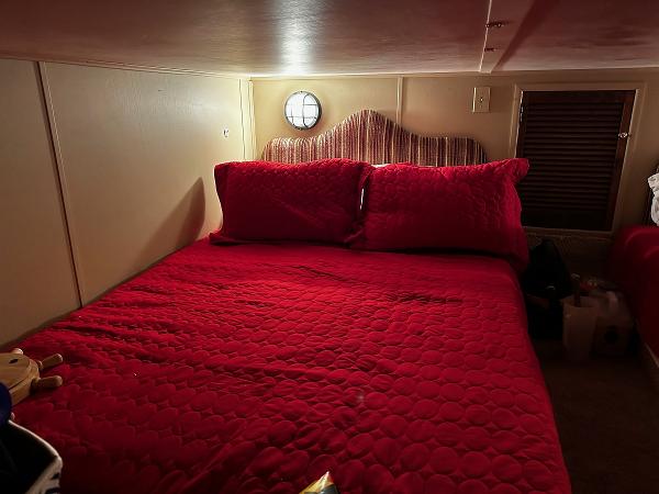 Slide: The Image of Cozy bedroom with red bedding in a 1987 Gibson 50 Classic boat. - 33