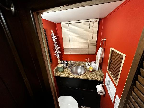 Slide: The Image of Compact bathroom in a 1987 Gibson 50 Classic boat with red walls and granite countertop. - 34