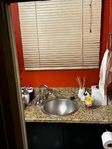 Slide: The Image of Small bathroom sink with granite countertop, red walls, and window blinds. - 36