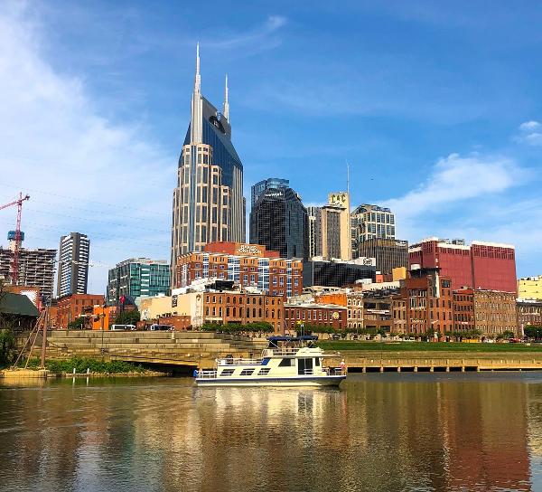 Slide: The Image of Boat on river with Nashville skyline and iconic AT&T building in the background. - 7