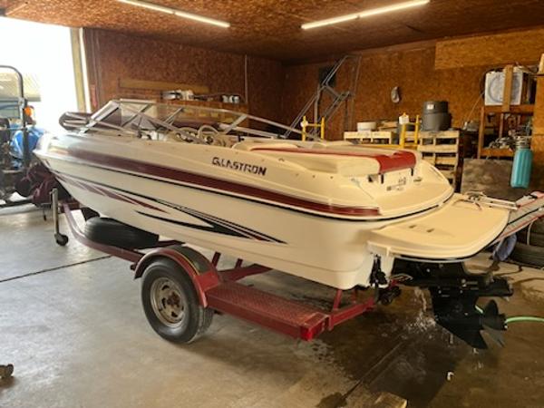 Slide: The Image of 2007 Glastron GT185 boat on trailer in a garage setting. - 1