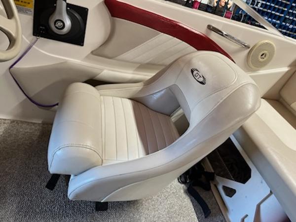 Slide: The Image of 2007 Glastron GT185 boat interior with white captain's seat and red accents. - 10