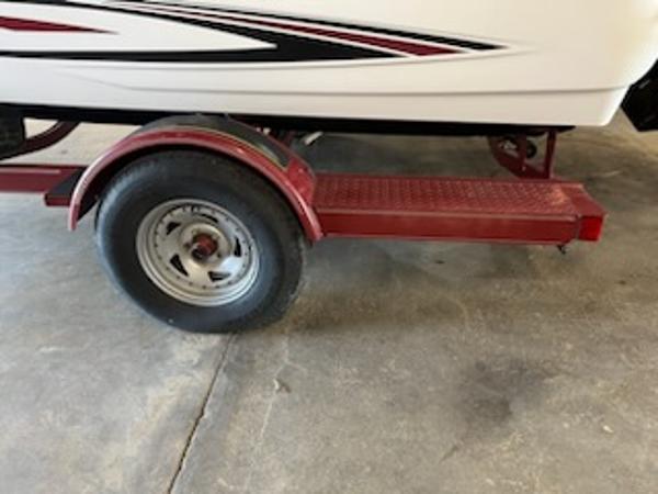 Slide: The Image of Red trailer with a 2007 Glastron GT185 boat, featuring a single wheel and fender. - 12
