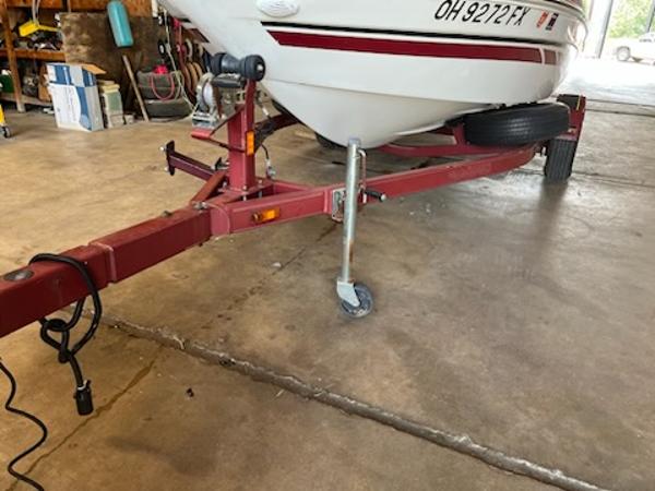 Slide: The Image of 2007 Glastron GT185 boat on red trailer in garage setting. - 13