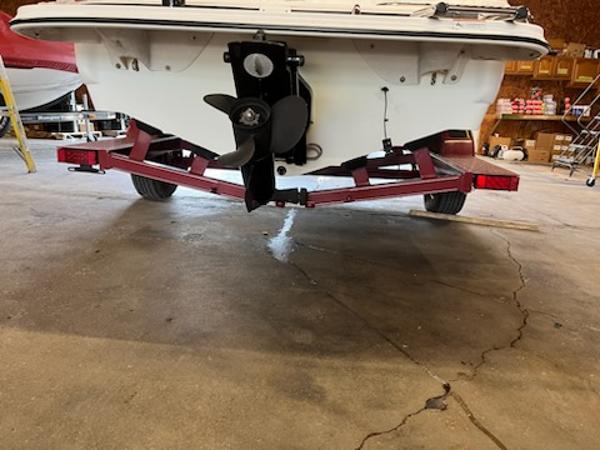 Slide: The Image of 2007 Glastron GT185 boat on red trailer in garage, showing propeller and stern. - 15