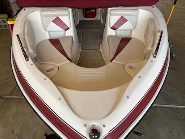 Slide: The Image of 2007 Glastron GT185 boat interior with red and white seating in a garage. - 2
