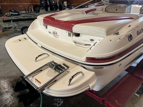 Slide: The Image of 2007 Glastron GT185 boat with red and white seating, rear view in a garage setting. - 5