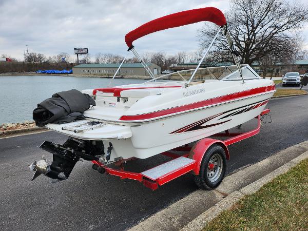 Slide: The Image of 2008 Glastron GT 205 boat with red accents on a trailer by a lake. - 1