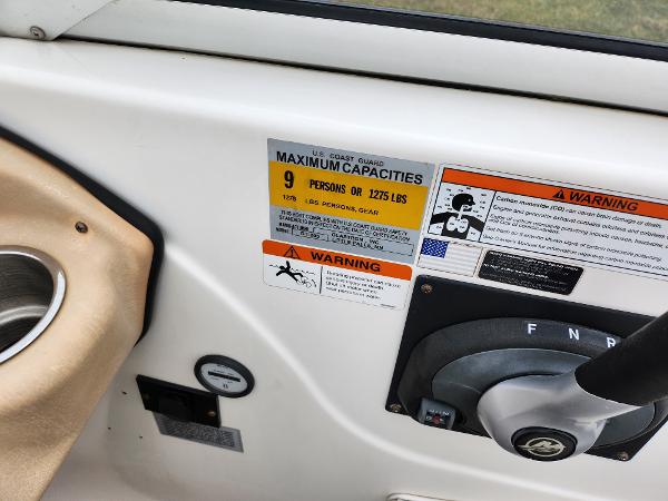 Slide: The Image of 2008 Glastron GT 205 boat capacity and warning labels near steering wheel. - 13