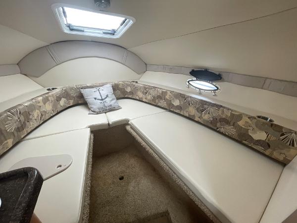 Slide: The Image of 2009 Glastron GT 249 cabin interior with cushioned seating and decorative pillow. - 12