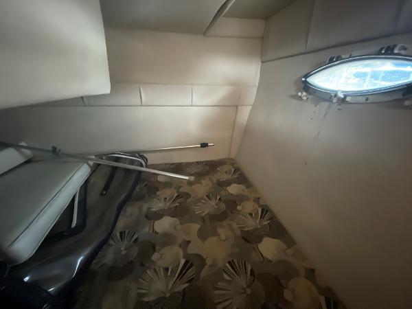 Slide: The Image of Interior cabin of a 2009 Glastron GT 249 boat with floral carpet and porthole window. - 17
