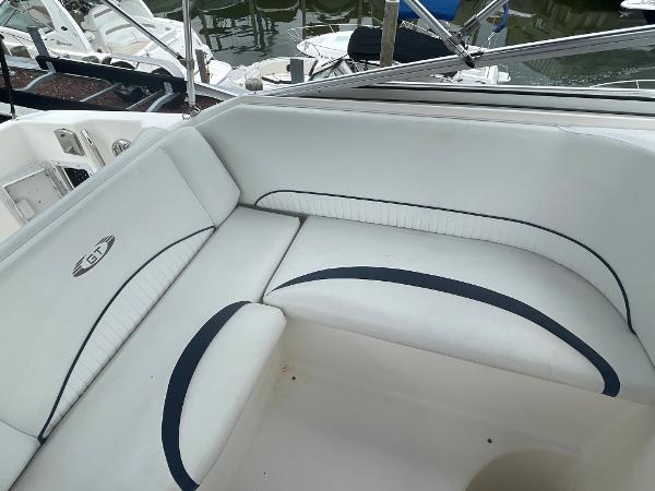 Slide: The Image of 2009 Glastron GT 249 boat interior seating area with white and blue upholstery. - 6