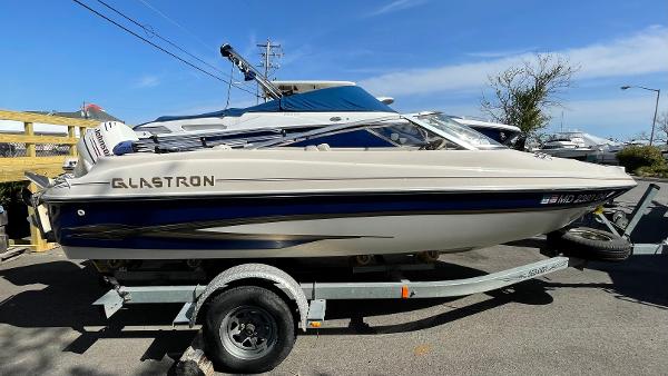 Slide: The Image of 2003 Glastron GX 180 Ski & Fish boat on a trailer in a marina. - 0