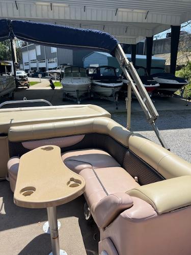 Slide: The Image of 2008 Godfrey SANPAN 2500 DC pontoon boat with beige seating and table, docked under shelter. - 6