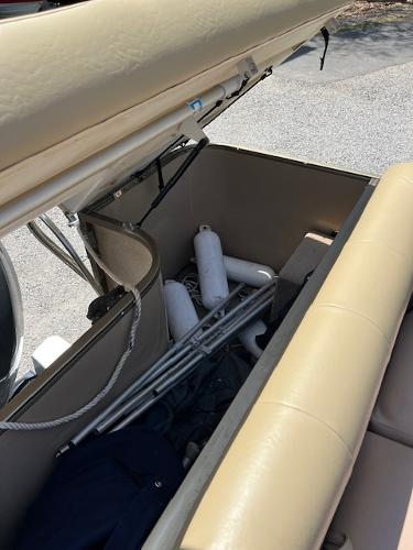 Slide: The Image of Open storage compartment in a 2008 Godfrey SANPAN 2500 DC boat with fenders and poles. - 7