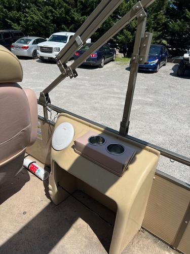 Slide: The Image of 2008 Godfrey SANPAN 2500 DC interior with cup holders and outdoor parking view. - 8