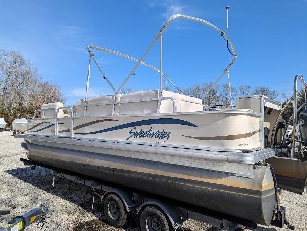 Slide: The Image of 2006 Godfrey Sweetwater pontoon boat on trailer under clear blue sky. - 0