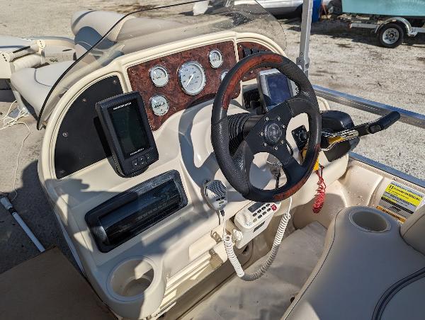 Slide: The Image of 2006 Godfrey Sweetwater boat dashboard with steering wheel and navigation instruments. - 11
