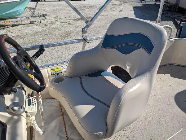 Slide: The Image of 2006 Godfrey Sweetwater boat seat with steering wheel and radio, in sunlight. - 13