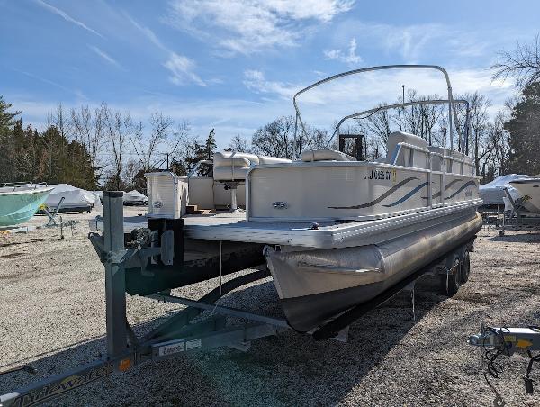 Slide: The Image of 2006 Godfrey Sweetwater pontoon boat on trailer in outdoor storage area. - 6