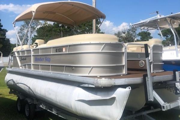 Slide: The Image of 2018 Godfrey Sweetwater 2286C pontoon boat on trailer with canopy, parked outdoors. - 1