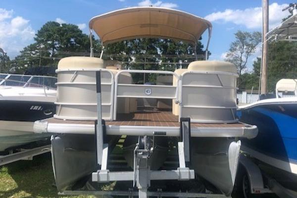 Slide: The Image of 2018 Godfrey Sweetwater 2286C pontoon boat on trailer, beige canopy, outdoor setting. - 5