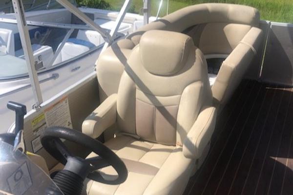 Slide: The Image of 2018 Godfrey Sweetwater 2286C boat interior with beige seating and steering wheel. - 9
