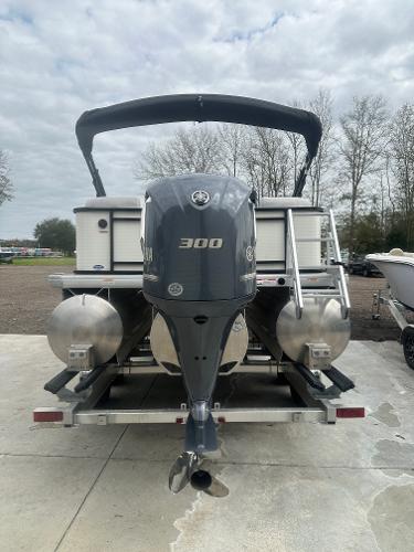 Slide: The Image of 2025 Godfrey SWEETWATER 2286 SB pontoon boat with powerful 300 HP engine, docked outdoors. - 2