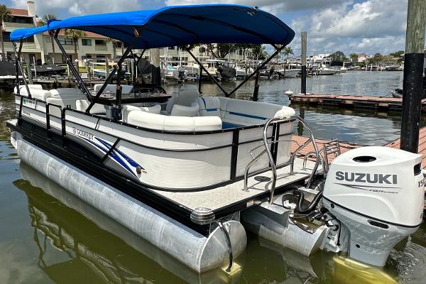 Slide: The Image of 2022 Godfrey Sw Mid Table Tri-Toon pontoon boat docked with Suzuki outboard motor. - 1