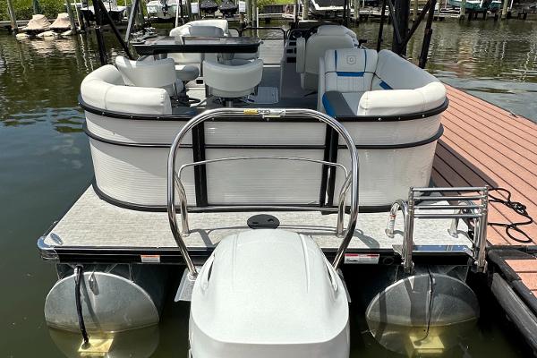 Slide: The Image of 2022 Godfrey Sw Mid Table Tri-Toon pontoon boat docked at marina. - 2