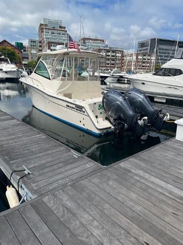 Slide: The Image of 2020 Grady-White 330 Express boat docked in a marina with twin outboard engines. - 1