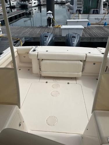 Slide: The Image of 2020 Grady-White 330 Express boat docked, showcasing spacious deck and twin outboard engines. - 6