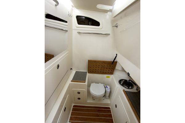 Slide: The Image of Manufacturer Provided Image: 2019 Grady-White Canyon 306 boat bathroom with toilet, sink, and wooden accents. - 17