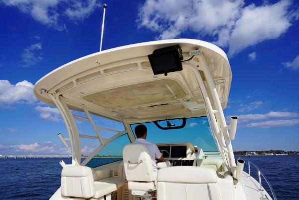Slide: The Image of 2016 Grady-White Express 330 boat on water, clear sky, person at helm. - 17