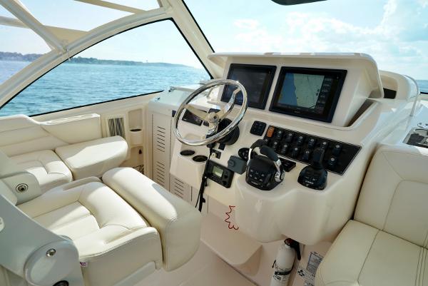 Slide: The Image of 2016 Grady-White Express 330 boat cockpit with steering wheel and navigation screens. - 33