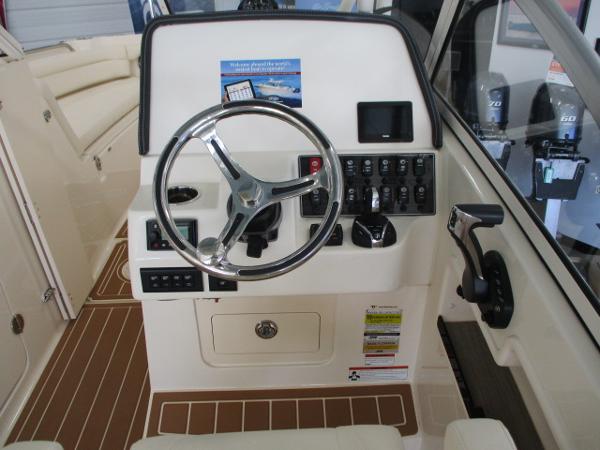 Slide: The Image of 2023 Grady-White Freedom 235 boat helm with steering wheel and control panel. - 4